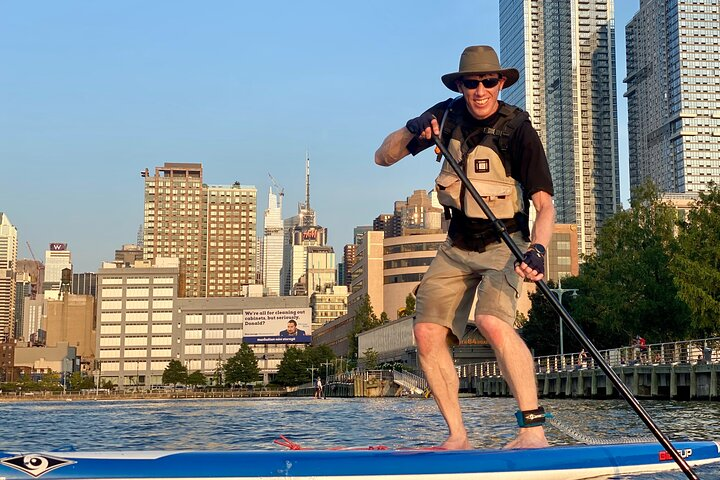 Progress from sitting to kneeling to standing on the paddle board.